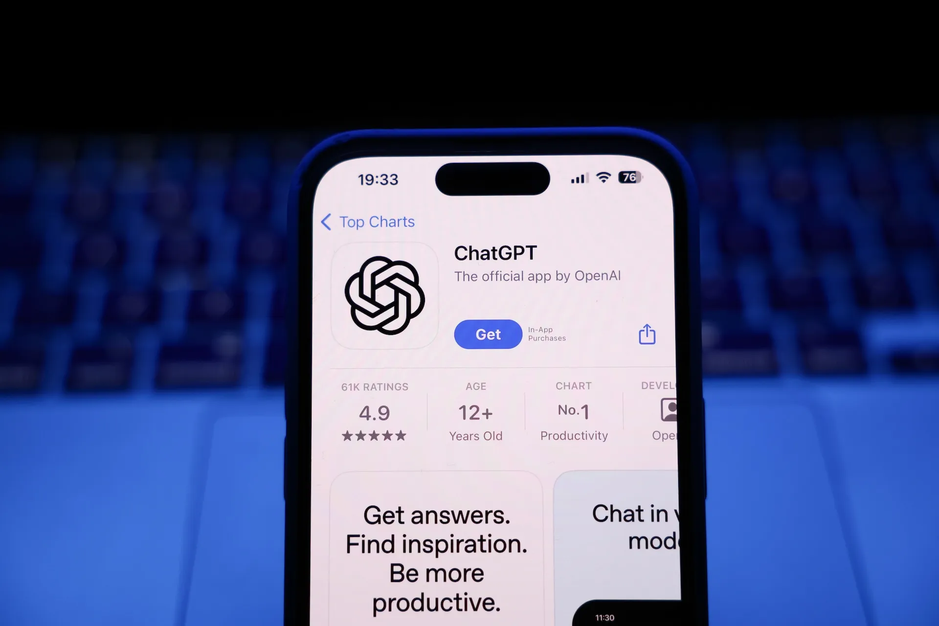 ChatGPT listing displayed on a smartphone in front of a laptop keyboard